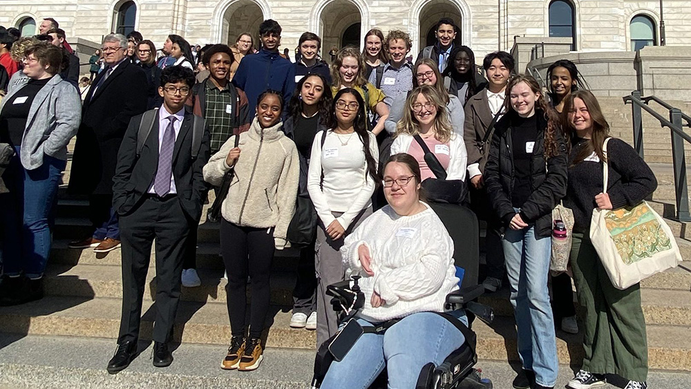 Middle- and high-school students pose for a group portrait on the steps of the Minnesota Capitol.